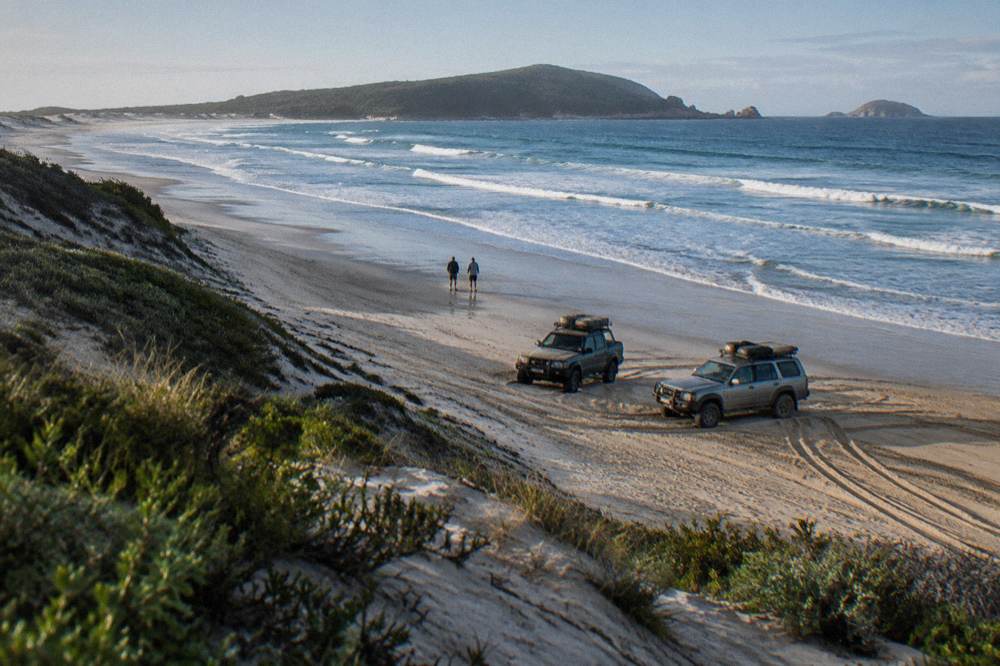 Four-wheel drive vehicles parked at the base of the Stockton Bight dunes near Anna Bay