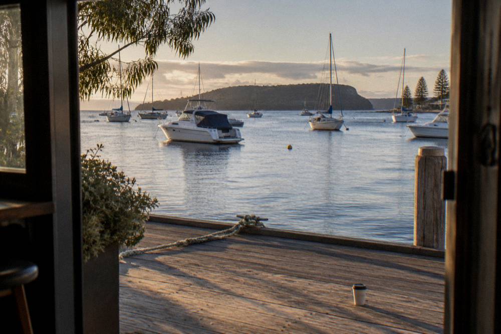 A sheltered bay with moored boats and a headland in the distance