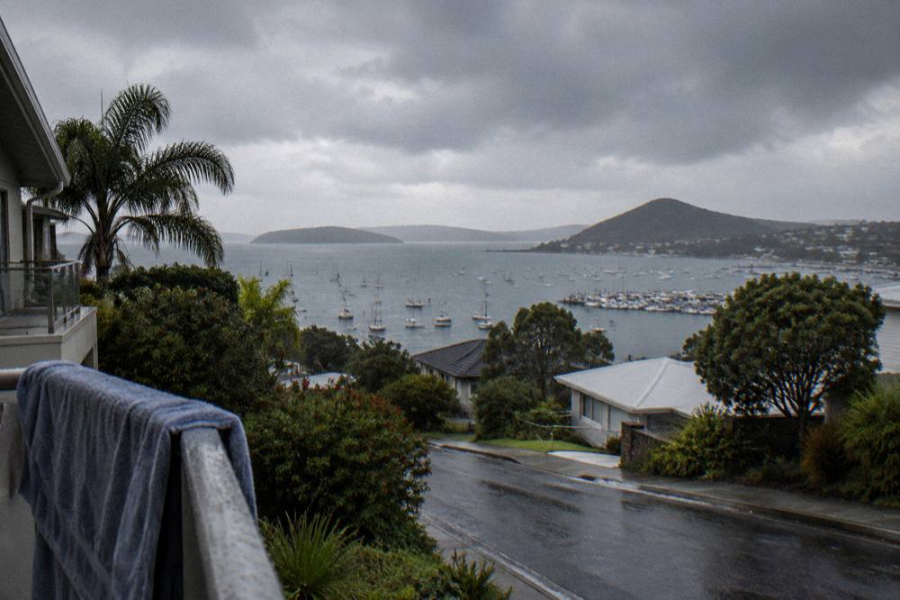 Rain clouds over a coastal town with a sheltered harbour below
